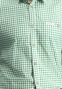 Grün-weiße karierte Button-Up-Bluse aus leichtem Stoff, mit einer Brusttasche und braunen Knöpfen sowie einem Logolabel.