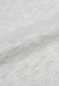 Tessuto grigio chiaro con una superficie morbida e texturizzata. Il materiale presenta un motivo leggermente marlato, che mostra sottili variazioni di colore.