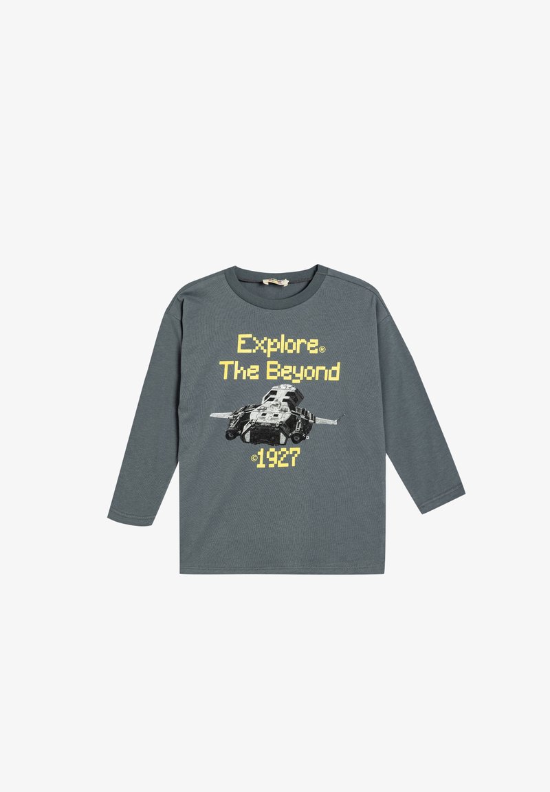 Graues Langarm-T-Shirt mit einem Grafikmotiv eines Fahrzeugs und dem Text "Explore The Beyond 1927" in gelber, pixelierter Schrift. Weicher Baumwollstoff.