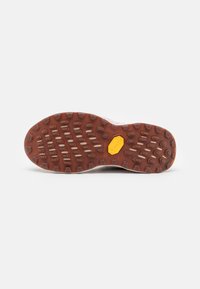 Suola di scarpa in gomma con un motivo marrone texturizzato e con lugs circolari per la trazione, evidenziata da un logo Vibram giallo al centro.