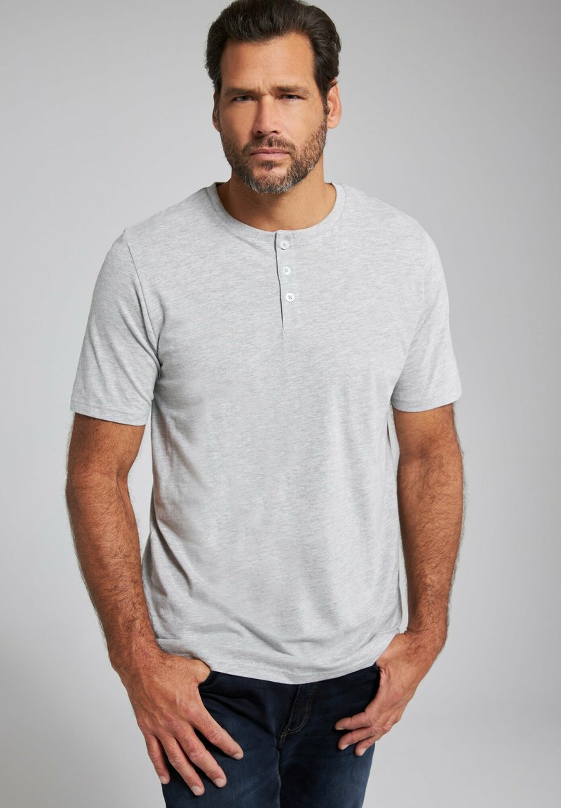 Maglietta henley a maniche corte grigia chiara realizzata in morbido cotone, con scollo rotondo e patta con tre bottoni. Vestibilità comoda, texture liscia.