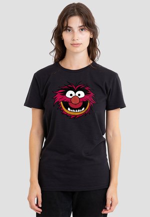 Black cotton t-shirt featuring a large graphic of a red monster face with white eyes, a red nose, and a wide smile, on a smooth texture.