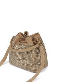 Bolso de cubo beige hecho de material suave, con una superficie texturada con tachuelas metálicas, cierre de cordón y correa de hombro desmontable.