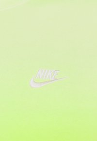 Neon grön Nike-tröja med en mjuk textur, som har en vit broderad logotyp på framsidan och en rundad halsringning.