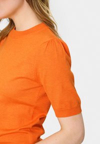 Top tricotat scurt de culoare portocalie cu mâneci scurte, având un guler rotund și umeri ușor bufanți, cu o textură fină și tiv ribflat.