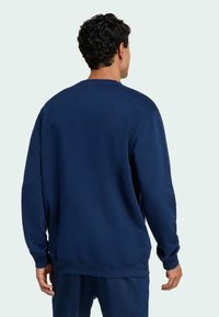 Navy blue sweatshirt made of soft material, featuring a crew neckline, long sleeves, and ribbed cuffs and hem. No visible graphics or patterns.
