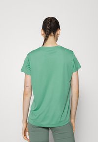 Camiseta verde de manga corta y corte relajado, hecha de una tela suave con un cuello redondo, que presenta una textura lisa y un mínimo de detalles.