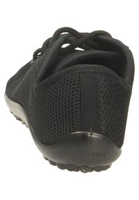 Black athletic shoe with a mesh upper, rubber sole, and textured detailing. Features laces and a flat heel for stability.