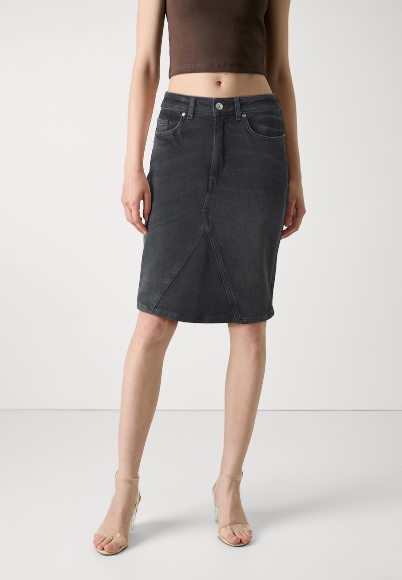 Tummanharmaa farkkukynähame, jossa on suora muotoilu, edessä halkio ja viisi taskua. Viimeistelty napilla ja vetskarilla.