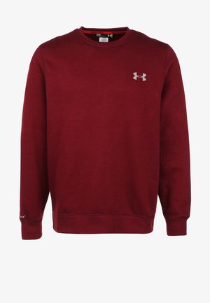 Sweatshirt bordeaux à manches longues et col rond, associé à un short noir et des chaussures de sport noires, avec un logo sous l'aisselle.