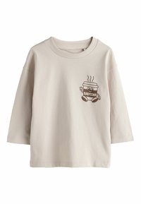 Világos bézs pamut hosszú ujjú ing, játszós barna rajzfilmszerű kávéscsésze grafikával, amely a "BABYCINO" feliratot viseli a mellkason.