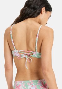 Zielony top bikini w różowy kwiatowy wzór, regulowane ramiączka oraz wiązane z tyłu z krzyżującymi się detalami. Gładka faktura tkaniny.