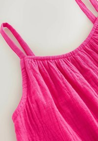 Robe en coton rose vif sans manches avec encolure froncée et fines bretelles, présentée sur fond blanc.