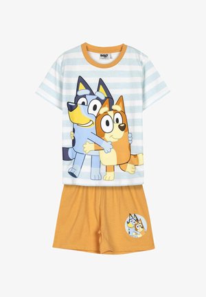 Gestreiftes Kurzarmhemd mit zwei Cartoon-Hunden, die sich umarmen, kombiniert mit senffarbenen Shorts mit dem gleichen Hundebild in einem Kreis.