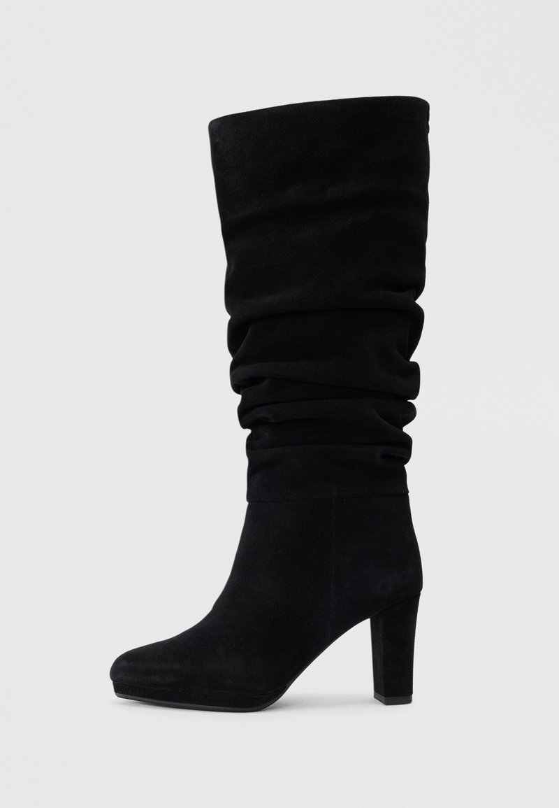 Botas de camurça pretas até ao joelho com um design descaído, bico afunilado e salto bloco. Textura suave e detalhes de hardware mínimos.