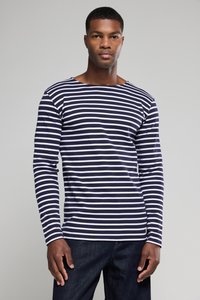 Marineblau-weiß gestreiftes Langarmshirt mit Bootsausschnitt, aus weichem Material, kombiniert mit dunklen Jeans. Auffällige horizontale Streifen.