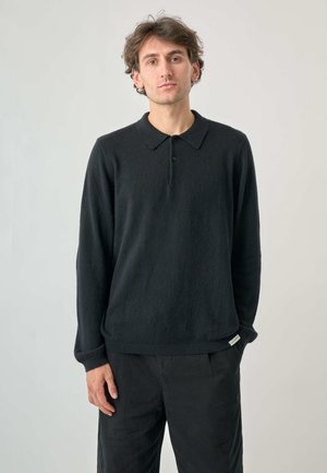 Schwarzer Strickpullover mit klassischem Kragen, langen Ärmeln und geripptem Saum. Hergestellt aus weichem Material mit dezenter Textur.