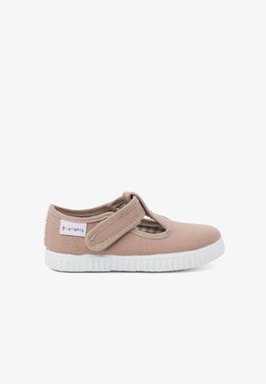 Bežiniai kanvos batai su Velcro dirželiu ir išpjovimų dizainu. Balta guma padidinta su tekstūruotu padu. Prekės ženklas ant šono.