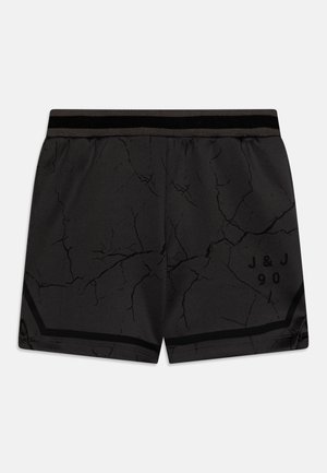 Schwarze Sportshorts mit einem Rissmuster, elastischem Bund mit einem schwarzen Streifen und einem gedruckten Logo "J & J 90" an der unteren Seite.
