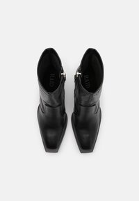 Černé kožené kotn�íkové boty se špičatou špičkou, s vertikálním prošíváním a bočním zipem se stříbrným kováním. Texturovaná vnitřní podšívka.