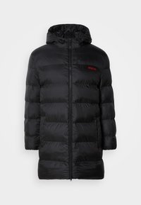 Chaqueta acolchada negra con capucha, con cremallera frontal y diseño de acolchado horizontal. Logo de la marca en rojo visible en el lado izquierdo del pecho.