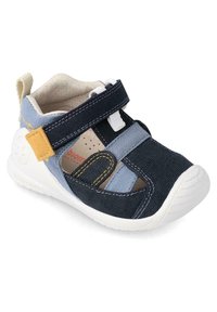 Sandalia de tela azul y navy con suela blanca, correa de gancho y bucle, acento amarillo y recortes transpirables para ventilación.