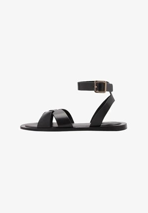 Sandale negre din piele, cu talpă plată. Prezintă curele încrucișate, o curea pentru gleznă cu o cataramă metalică și un design minimalist.