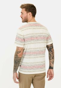 Gestreept T-shirt in crème met horizontale lijnen in roze, bruin en grijs. Korte mouwen en een losse pasvorm. Katoenen textuur.