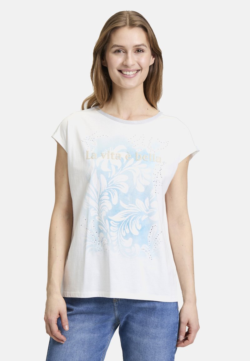 White short-sleeve t-shirt featuring a blue floral pattern and the text “La vita è bella” in gold, with subtle embellishments.