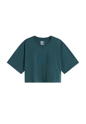 T-shirt turquoise à manches courtes et coupe courte, avec un col rond et un subtil design brodé de quatre cercles formant "2 A U S" au centre avant.