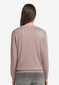 Helles rosa, langärmliges Sweatshirt mit Rundhalsausschnitt und geripptem Saum. Weicher Stoff, keine Muster oder Akzente aus der Rückenansicht sichtbar.