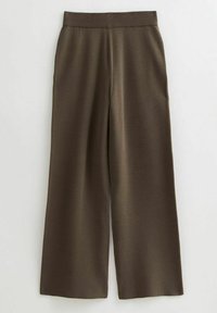 Pantalons larges en tissu marron foncé. Dotés d'une taille élastique côtelée. Texture lisse avec un design minimaliste. Sans motifs ni accents.