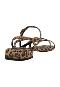 Sandalias de estampado de leopardo con suela plana y plataforma, tiras delgadas y hebilla ajustable. Fabricadas en un material suave similar al ante.