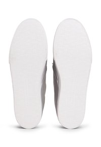 Baskets en tissu gris avec semelles extérieures en caoutchouc blanc. Les semelles présentent un motif texturé, et les côtés ont un design cousu avec un marquage subtil.