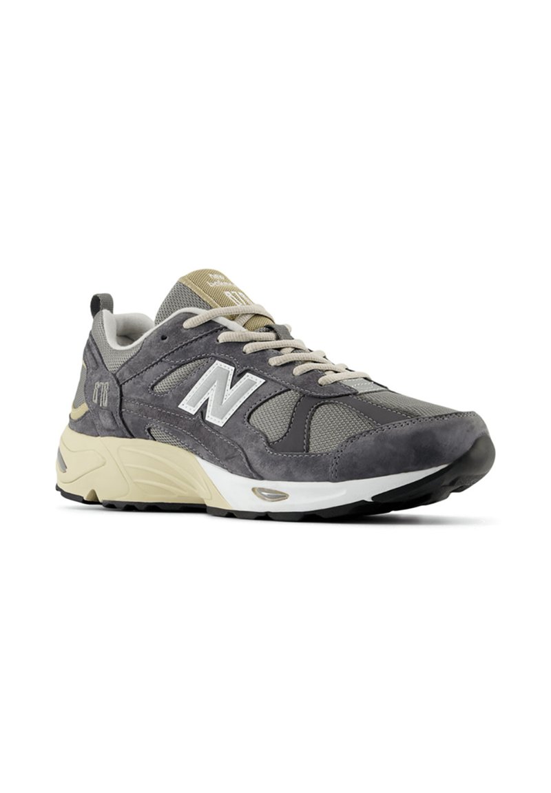 Sneaker in suede grigio e rete con suola beige, caratterizzato da logo laterale, dettagli texture e lacci rotondi. Progettato per comfort e stabilità.