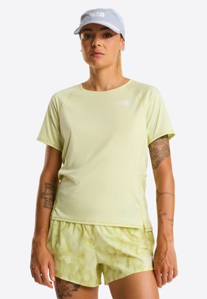 Lysegul tekstureret sportst-shirt med korte ærmer og rund halsudskæring, kombineret med lysegule shorts med mønster.