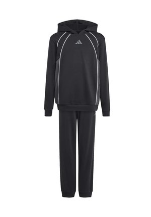 Twee jonge mensen die zwarte hoodies en bijpassende broeken dragen, staan rug aan rug en kijken in tegenovergestelde richtingen.