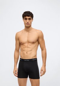 Svarta boxershorts med mjuk textur och åtsittande design. Resårmidjan har "Calvin Klein"-logotypen i vitt.