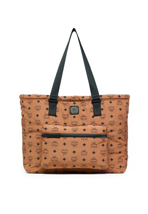 Brun MCM skuldertaske med sort logo mønster, frontlomme med lynlås og lange sorte håndtag mod hvid baggrund.