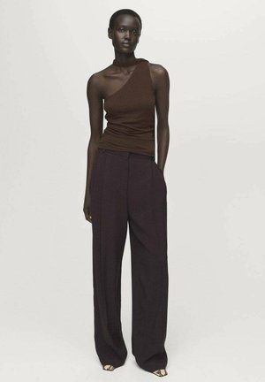 Haut asymétrique marron en tissu côtelé associé à un pantalon large taille haute de couleur violet foncé. Design minimaliste et silhouette ajustée.