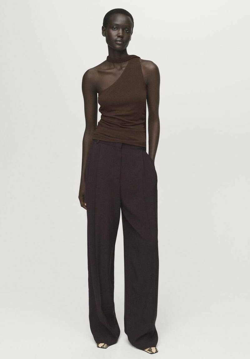 Top cu umăr unic de culoare marron, realizat dintr-un material cu nervuri, asortat cu pantaloni largi de culoare violet închis, cu talie înaltă. Design minimalist și siluetă mulată.
