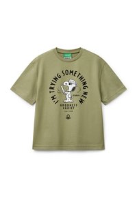 Olivegrünes Baumwoll-T-Shirt mit einem schwarzen grafischen Cartoonhund und dem Text: "ICH PROBIERE ETWAS NEUES GUTEN UND TRAUER SEIT 1950."