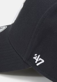 Gorra de béisbol de la marina hecha de un tejido texturizado, con un logo y acentos bordados en blanco. Visera curvada, correa ajustable y diseño limpio.