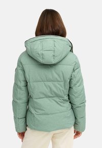 Vadderad grön jacka med huva, med horisontell quiltad design, mjuk textur och kontrasterande kant längs halsen och huvan.