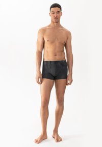 Boxers noirs avec un motif à carreaux, fabriqués en tissu doux, offrant une coupe ajustée et une taille élastique pour le confort.