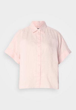 Camisa de botones de manga corta en rosa claro, hecha de lino; cuenta con un cuello clásico y un corte relajado, con una superficie suave y ligeramente texturada.