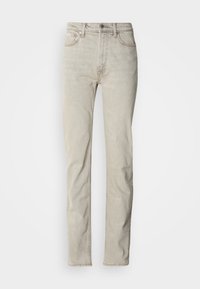 Bēšas džinsa bikses ar taisnu kāju griezumu, piecu kabatu stilu un pogas aizdari. Tām ir smalka tekstūra un minimālas šūšanas detaļas.