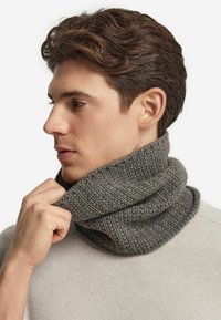 Strikket grå cowl neck-halstørklæde med et tekstureret mønster. Båret tæt om halsen, parret med en let sweater.