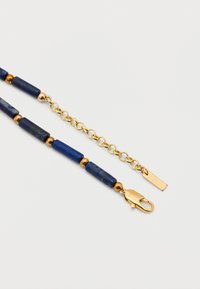 Κολιέ με αλυσίδα από χρυσό με σκούρες μπλε κυλινδρικές και στρογγυλές χάντρες, διαθέτει κούμπωμα καβουριού και ρυθμιζόμενη αλυσίδα με μικρή ετικέτα.
