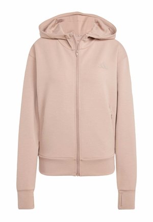 Lys rosa zip-up hoodie med lange ærmer, tommelhuller i manchetterne og et subtilt logo på venstre bryst.